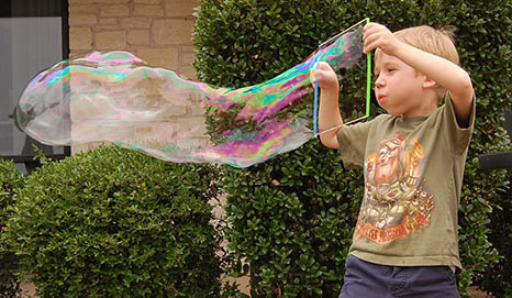 a boy blowing a bubble